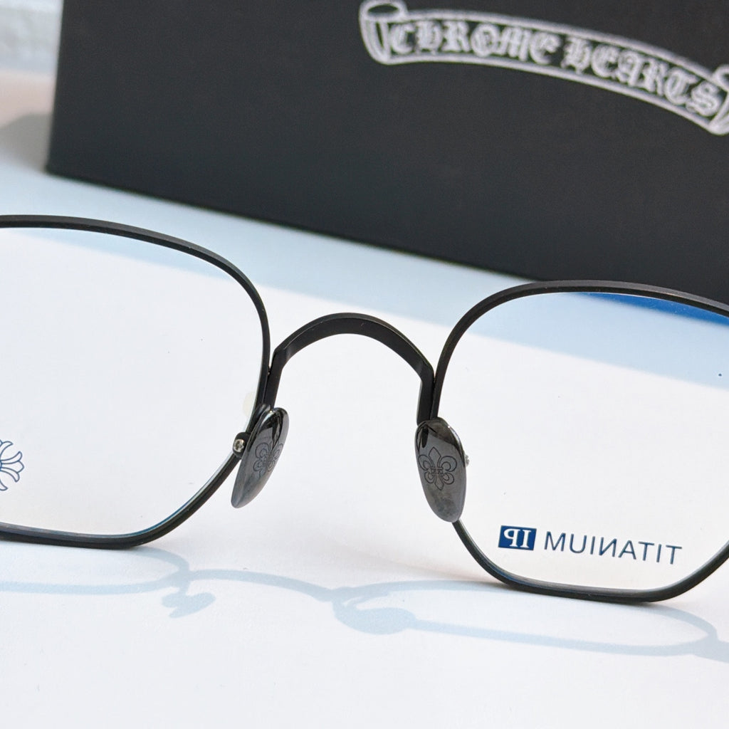 Round black eyeglasses with blue-tinted lens panels and small side emblem