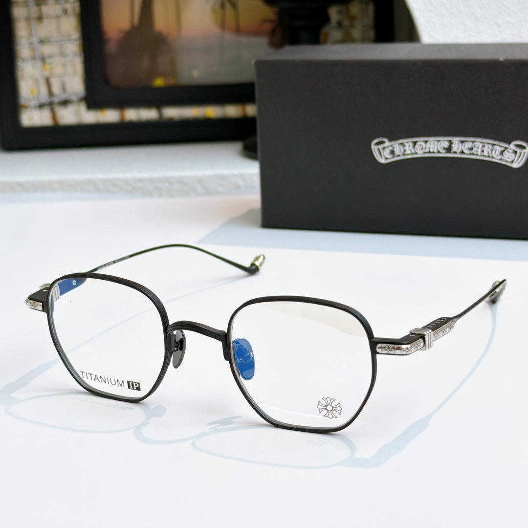 Round eyeglasses with dark frame, blue-tinted lenses, and patterned metal temples