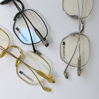 Set of eyeglasses in gold and black frames with blue-tinted lenses and metal temples