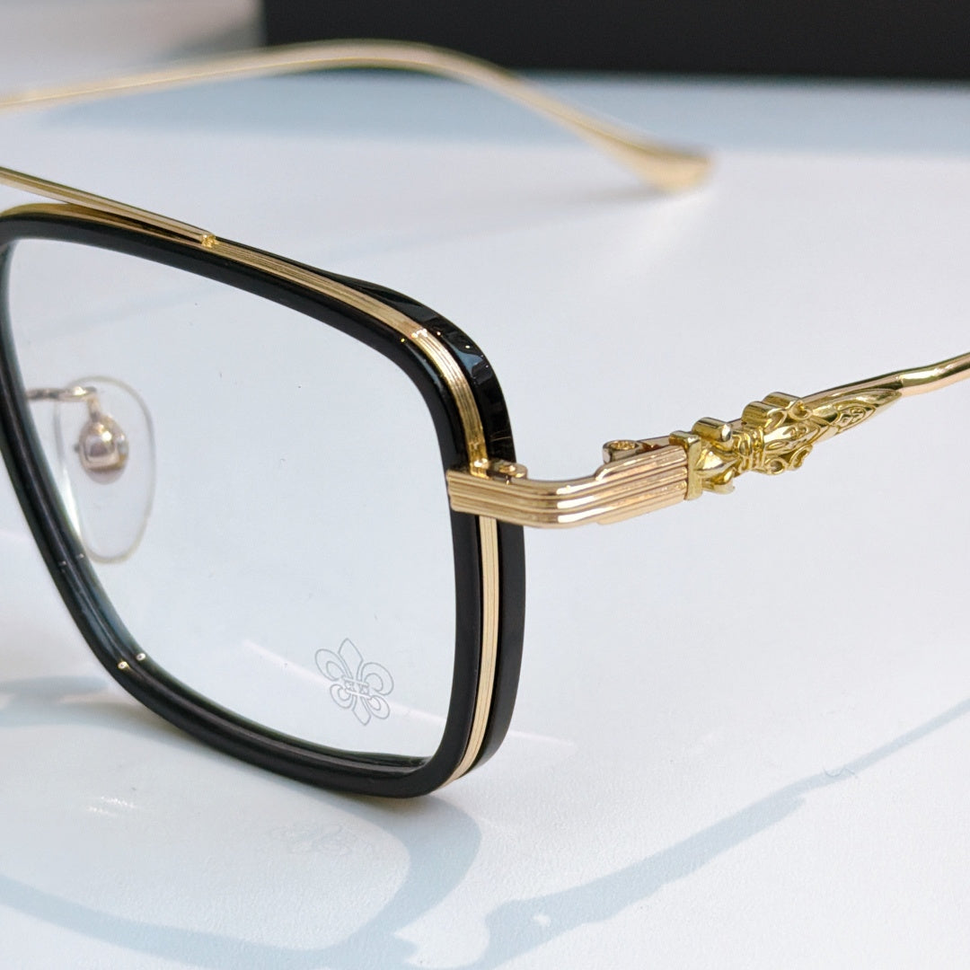 Close-up of gold eyeglass frame with decorative temple and clear lens