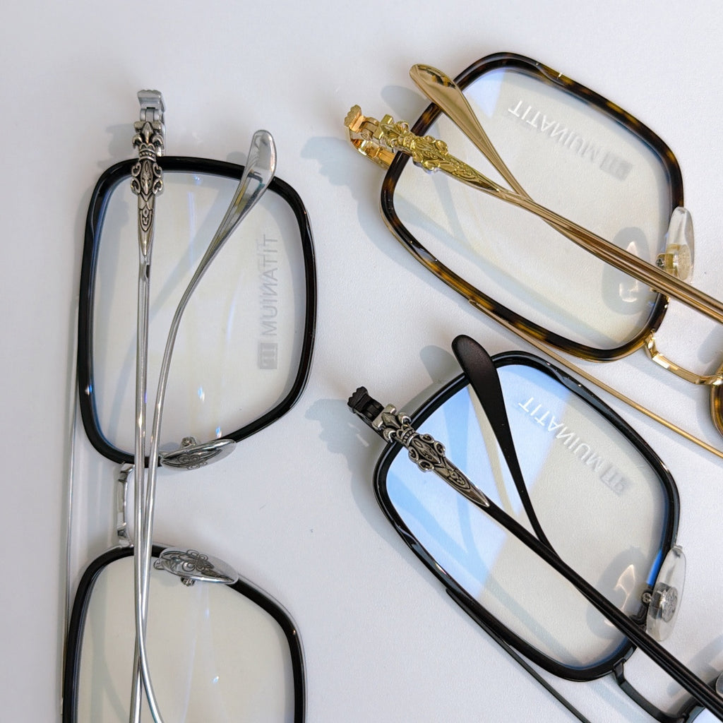 Assorted eyeglass frames, including gold, silver, and black styles with clear lenses