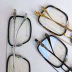 Assorted eyeglass frames, including gold, silver, and black styles with clear lenses