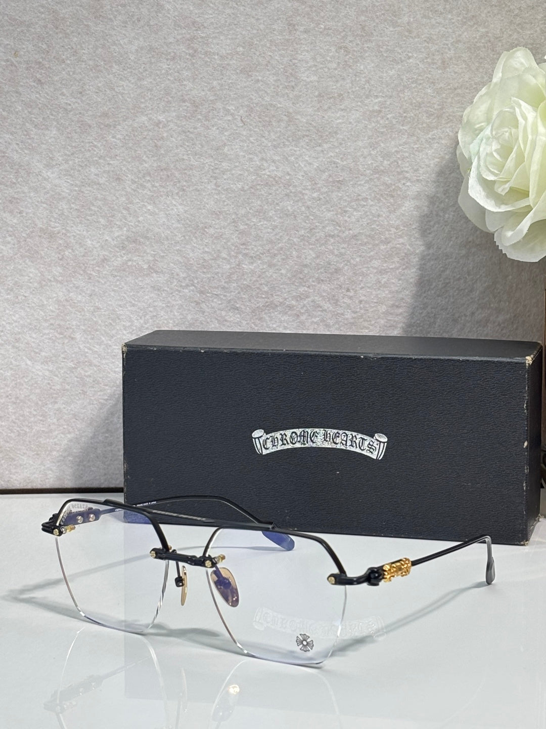 Chrome eyeglasses with dark frame front, gold temple details and clear lenses