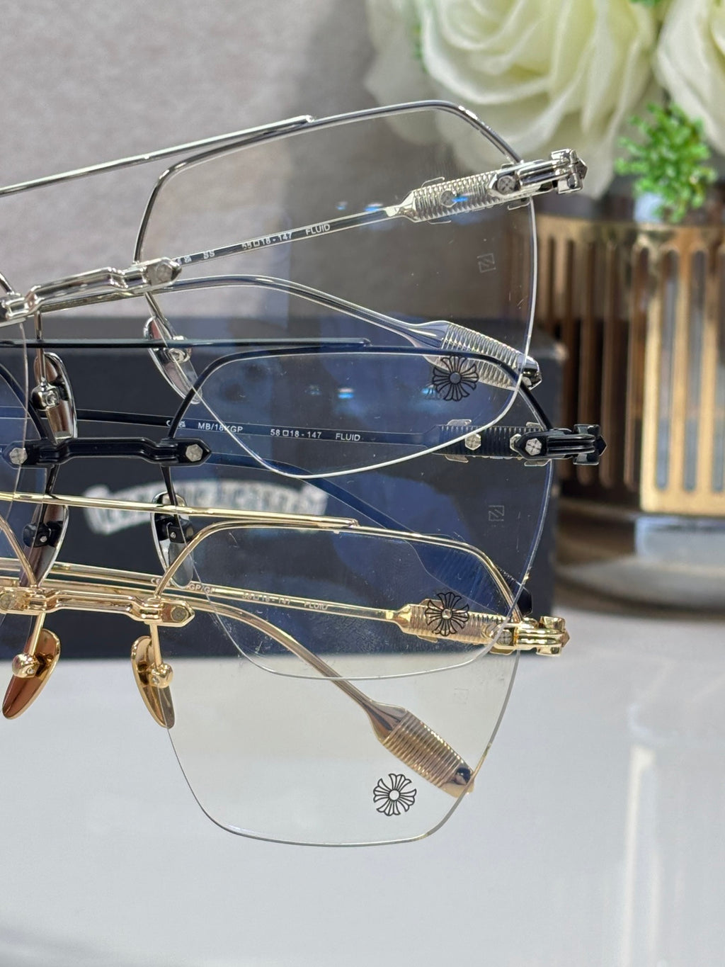 Chrome eyeglasses with clear lenses and blue front frames, stacked