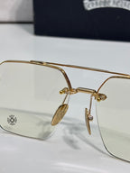 Gold-tone eyeglasses closeup with clear lens and decorative metal bridge