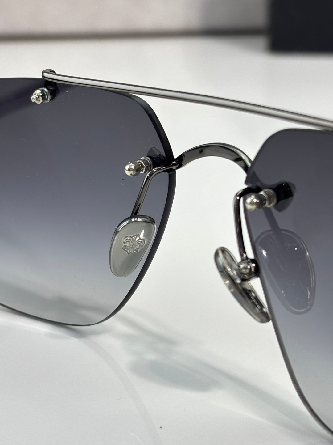 Chrome glasses with dark lenses and silver metal frame, close side profile