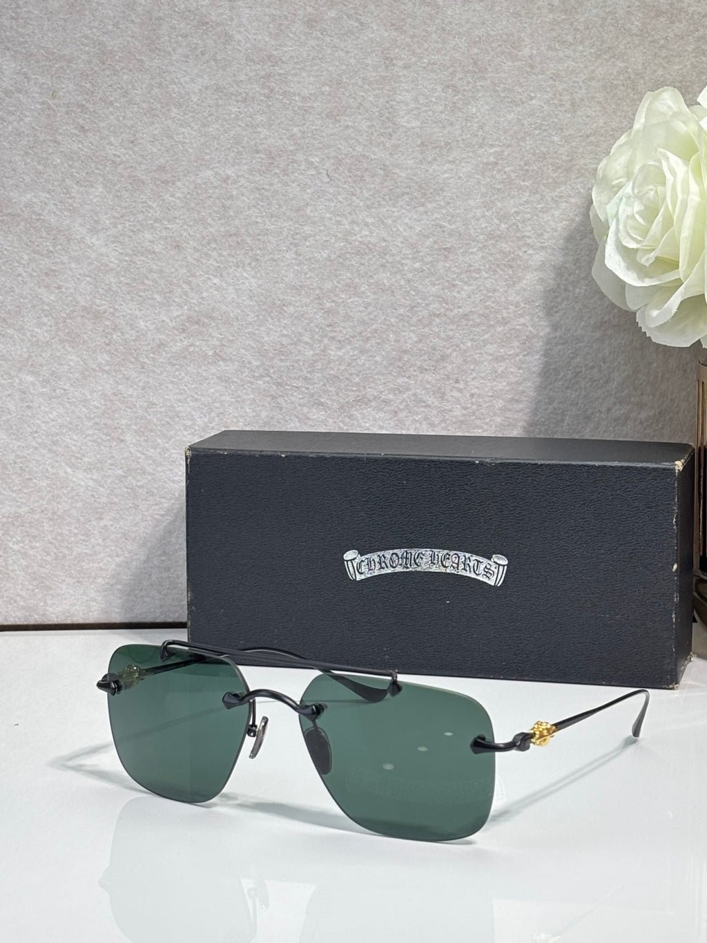 Chrome glasses with green-tinted lenses and dark metal frame, front view