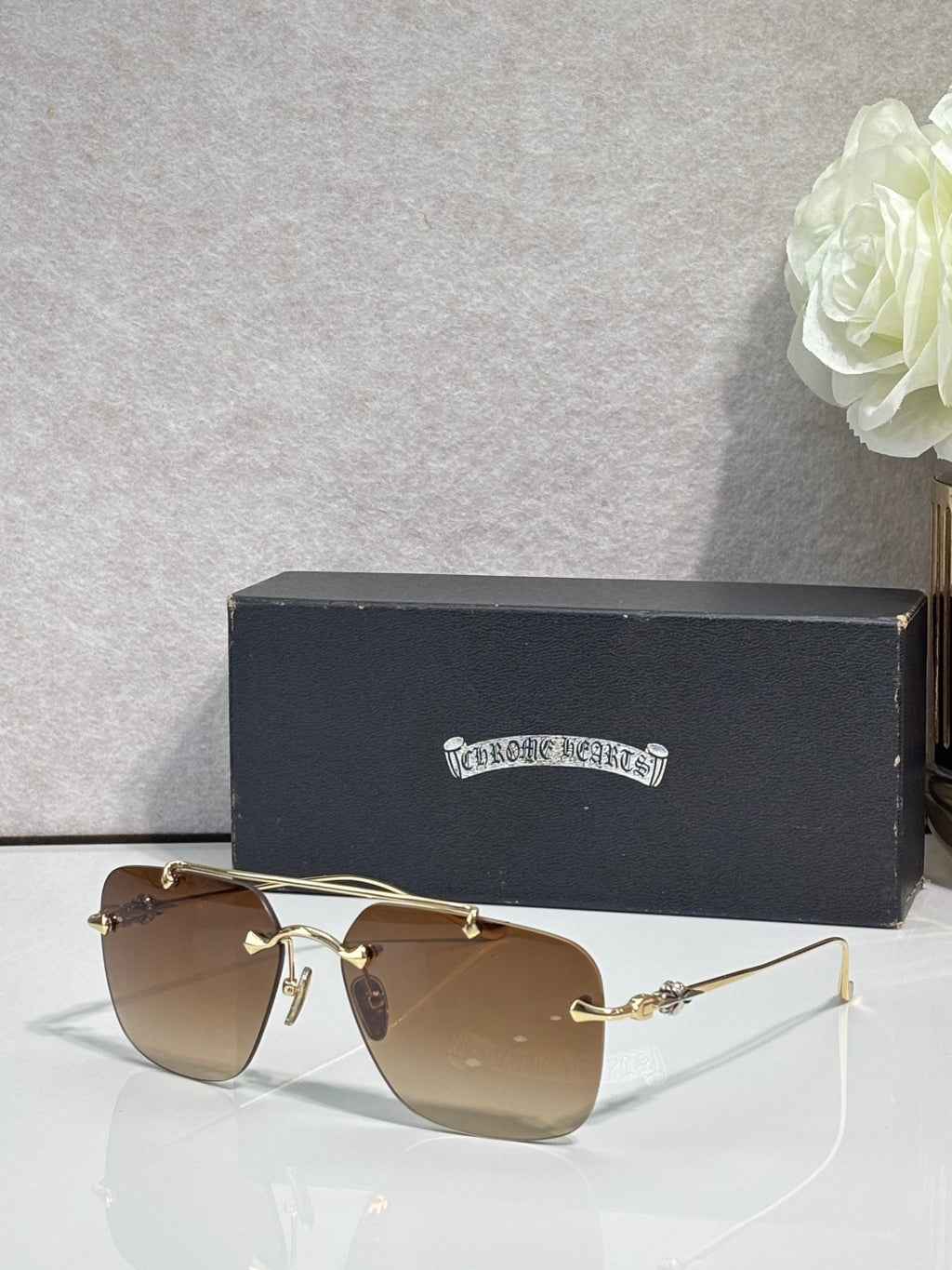 Chrome glasses with brown-tinted lenses and gold-toned metal frame, side view