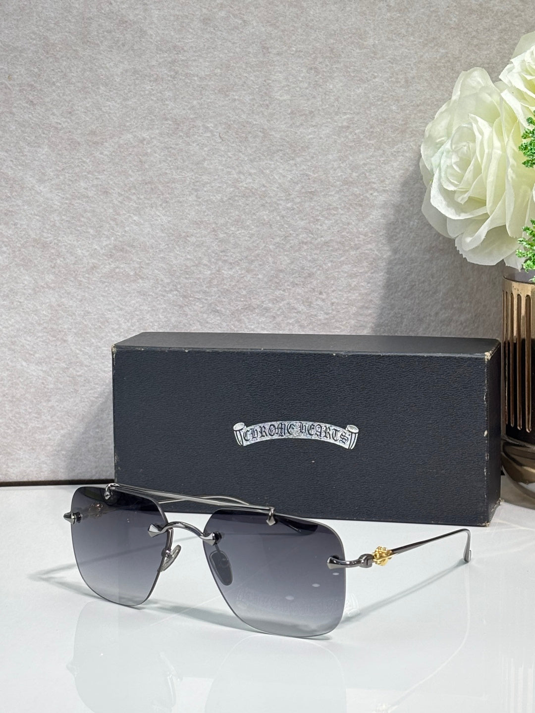 Chrome glasses with dark blue lenses and silver metal frame, angled view