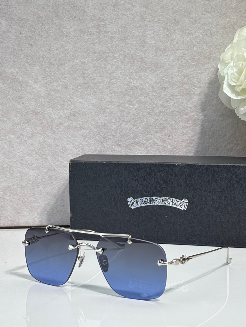 Chrome glasses with blue-tinted lenses and silver metal frame, side view