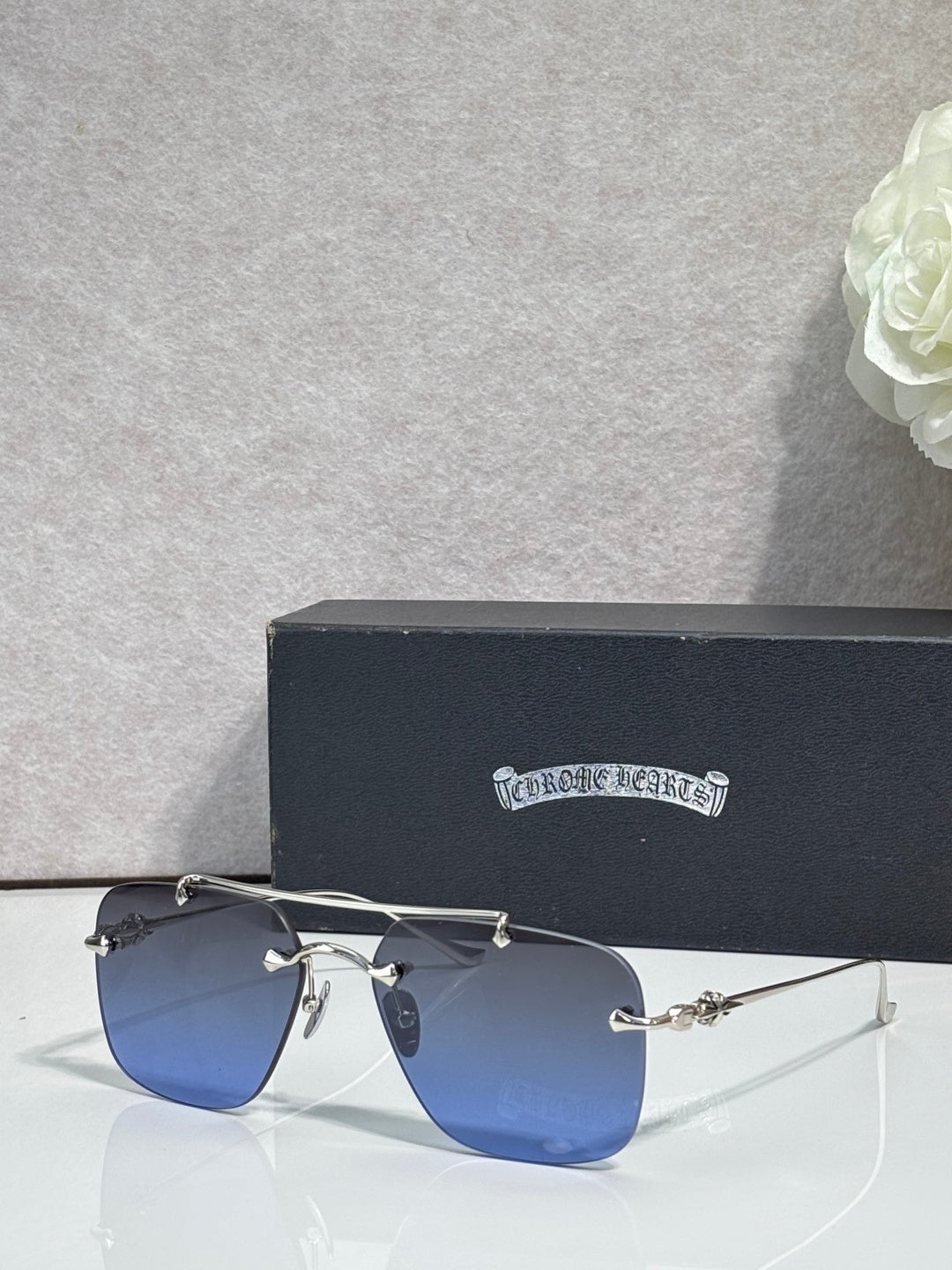 Chrome glasses with blue-tinted lenses and silver metal frame, side view