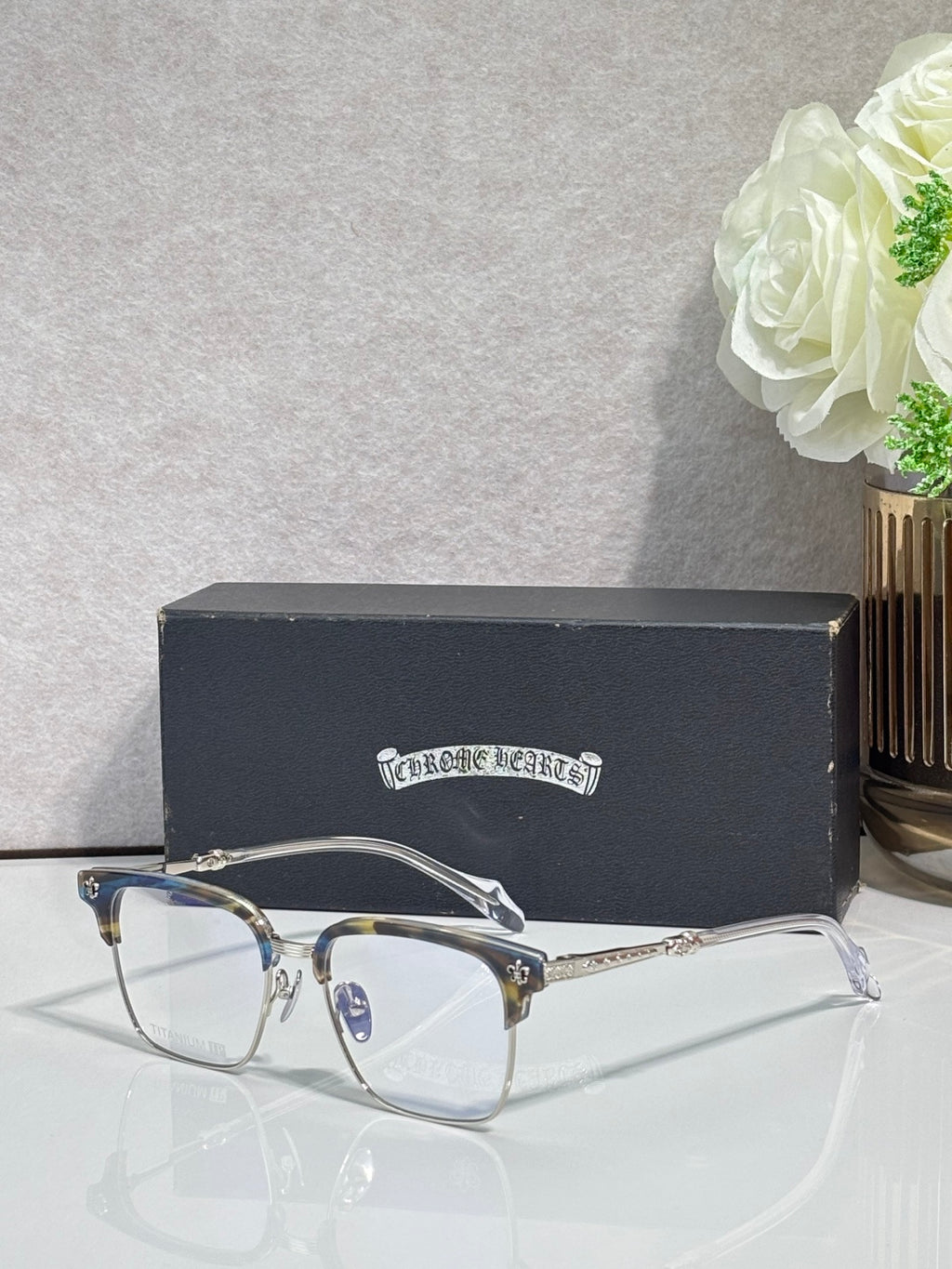 Metal eyeglasses with clear lenses, gold arms, and arched bridge