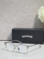 Metal eyeglasses with clear lenses and gold-toned frame with engraved detailing