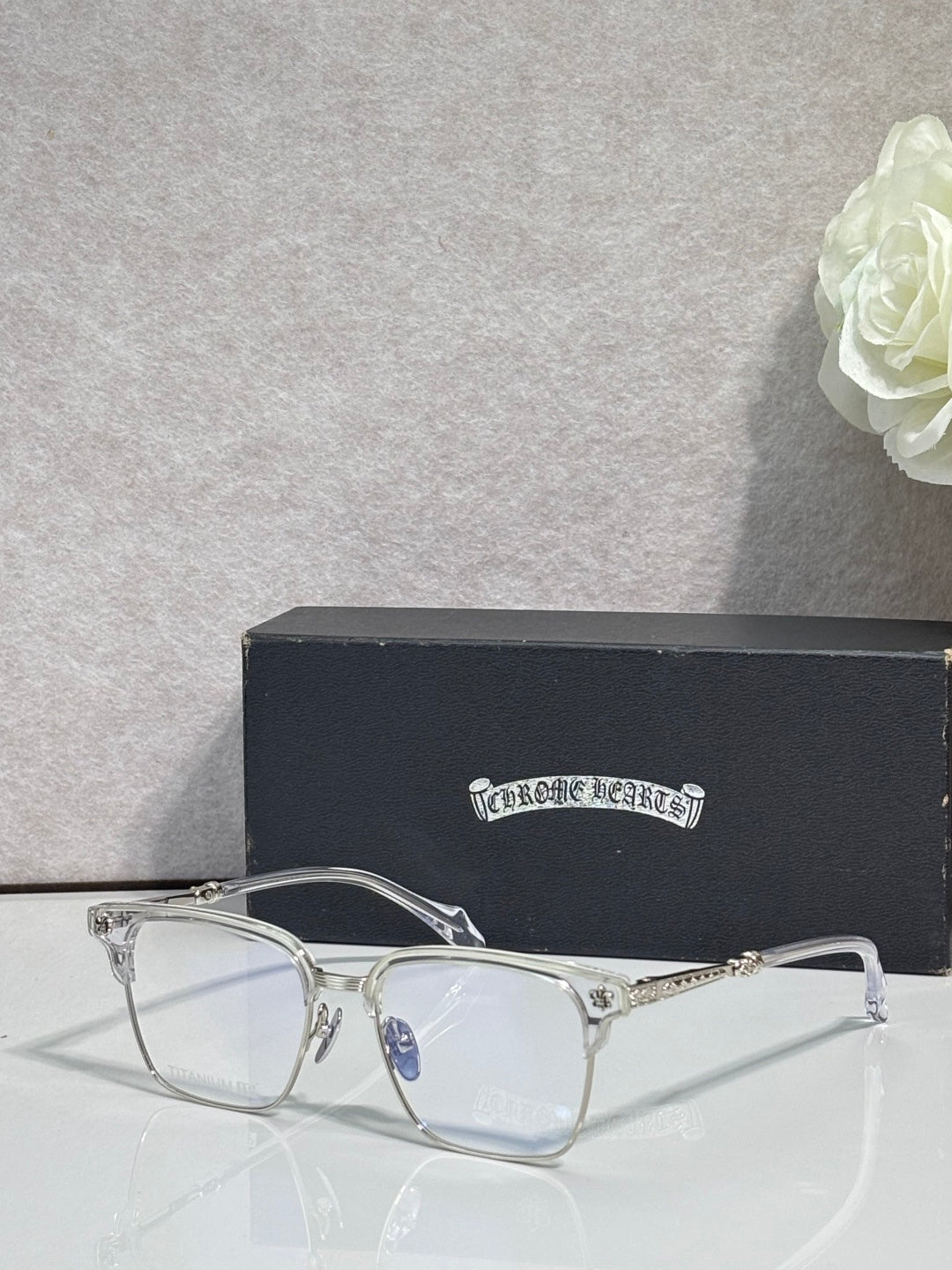 Metal eyeglasses with clear lenses, arched bridge, and gold-toned temples