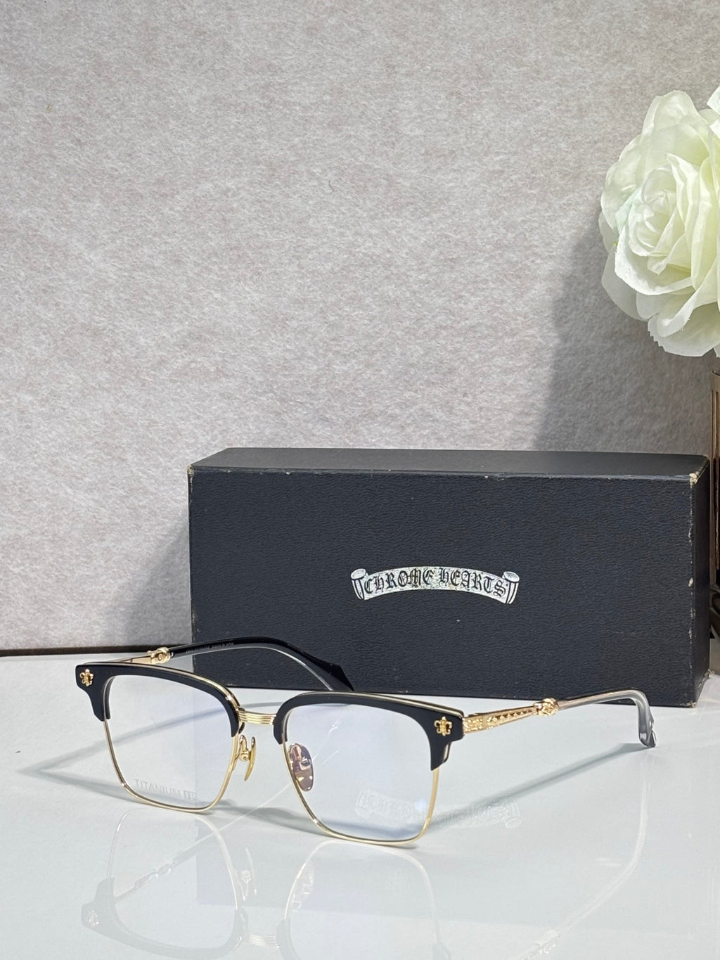 Metal eyeglasses with clear lenses, gold arms, and dark temple tips