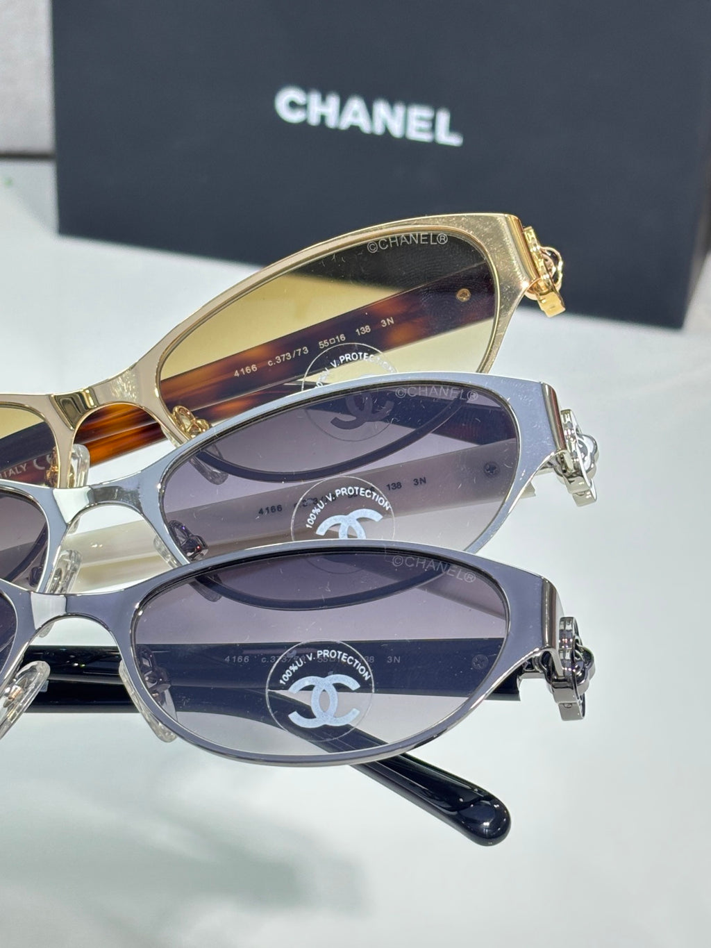 Stacked oval sunglasses with gold and silver frames and gradient dark lenses