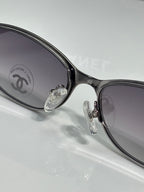 Close-up of black sunglasses with round lenses and silver hinge detail