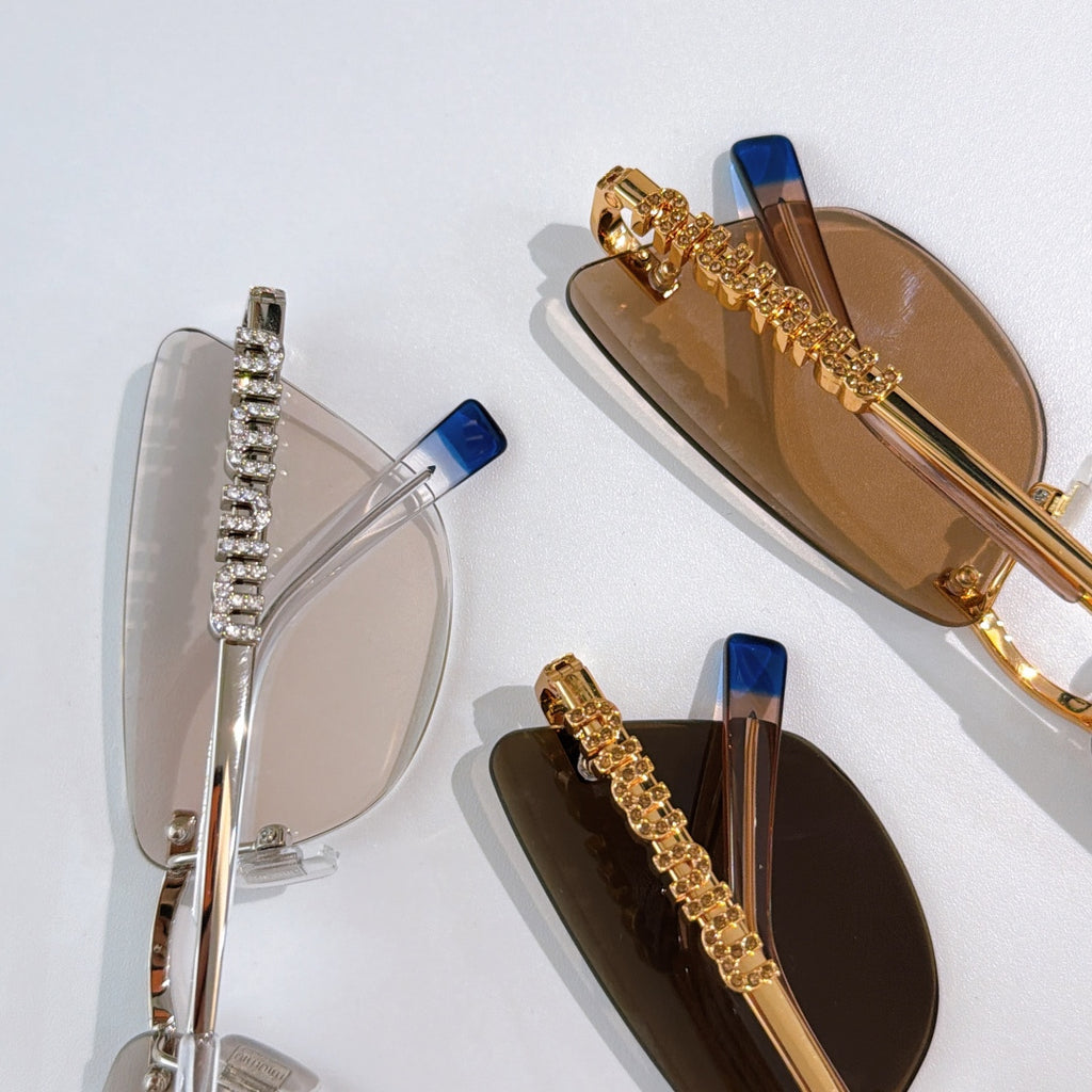 Two pairs of sunglasses: clear-lens silver frame and amber-lens gold frame