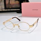 MiuMiu round eyeglasses with gold metal frames and clear lenses, tortoiseshell temple tips
