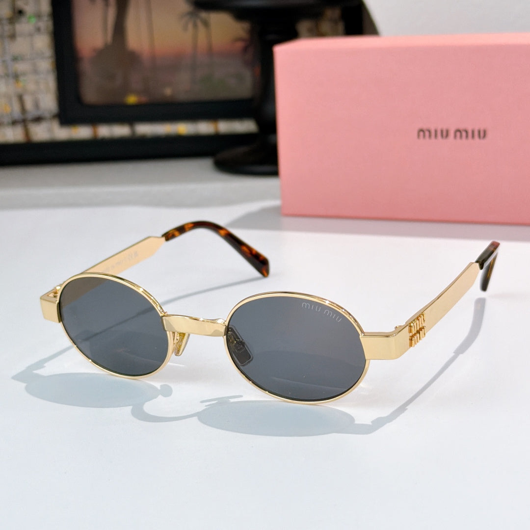 MiuMiu round sunglasses with gold frames, dark blue lenses, and tortoiseshell temple tips