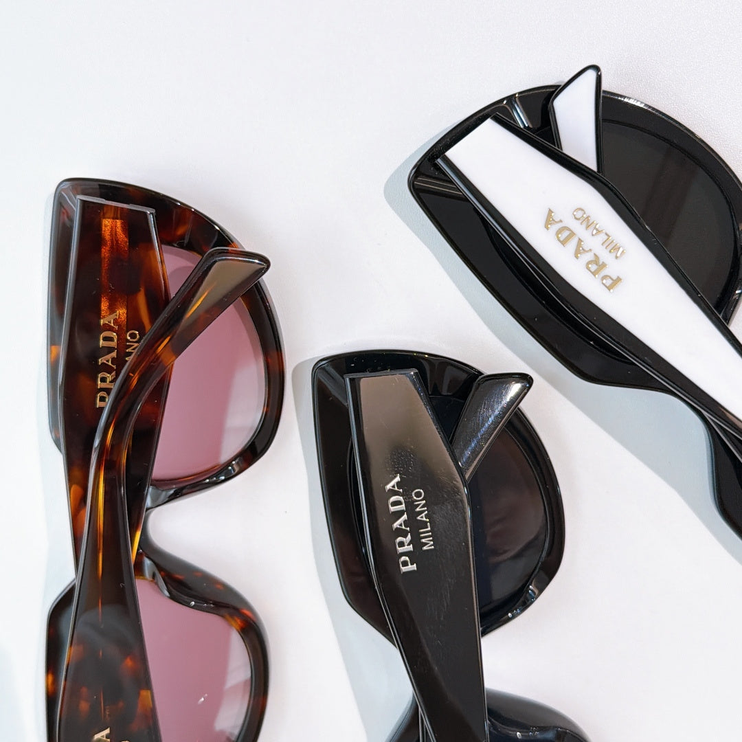 Prada sunglasses close-up: tortoiseshell and black frames with logo temples