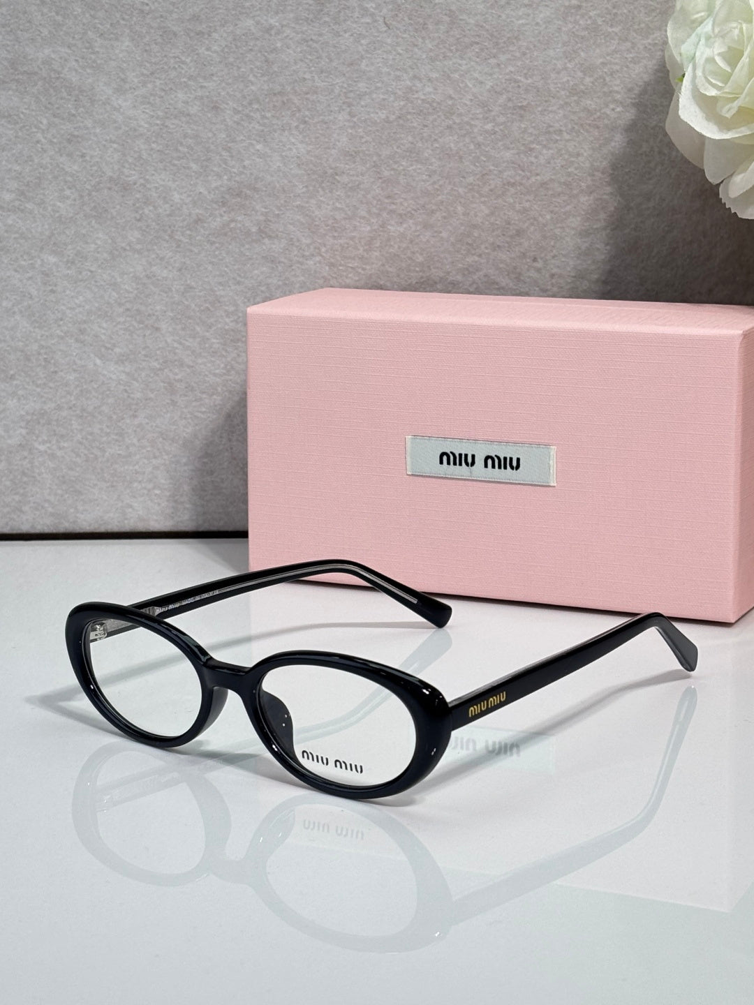 Eyeglasses with dark tortoiseshell round frames and clear lenses, side logo.
