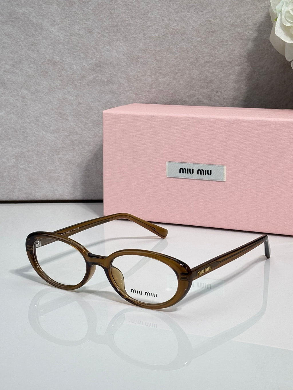 Eyeglasses with brown tortoiseshell round frames and clear lenses, temple logo.