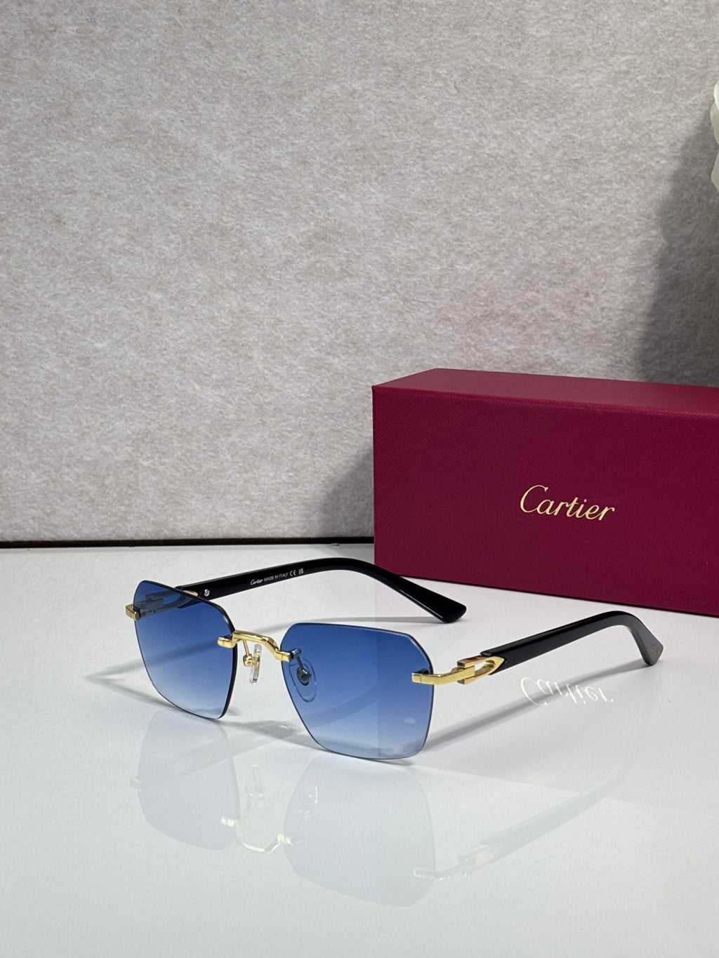 Cartier sunglasses with blue lenses and black frame with gold-tone details