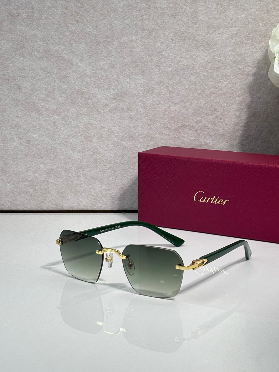Cartier sunglasses with green-tinted lenses, clear frame arms, and gold-tone details