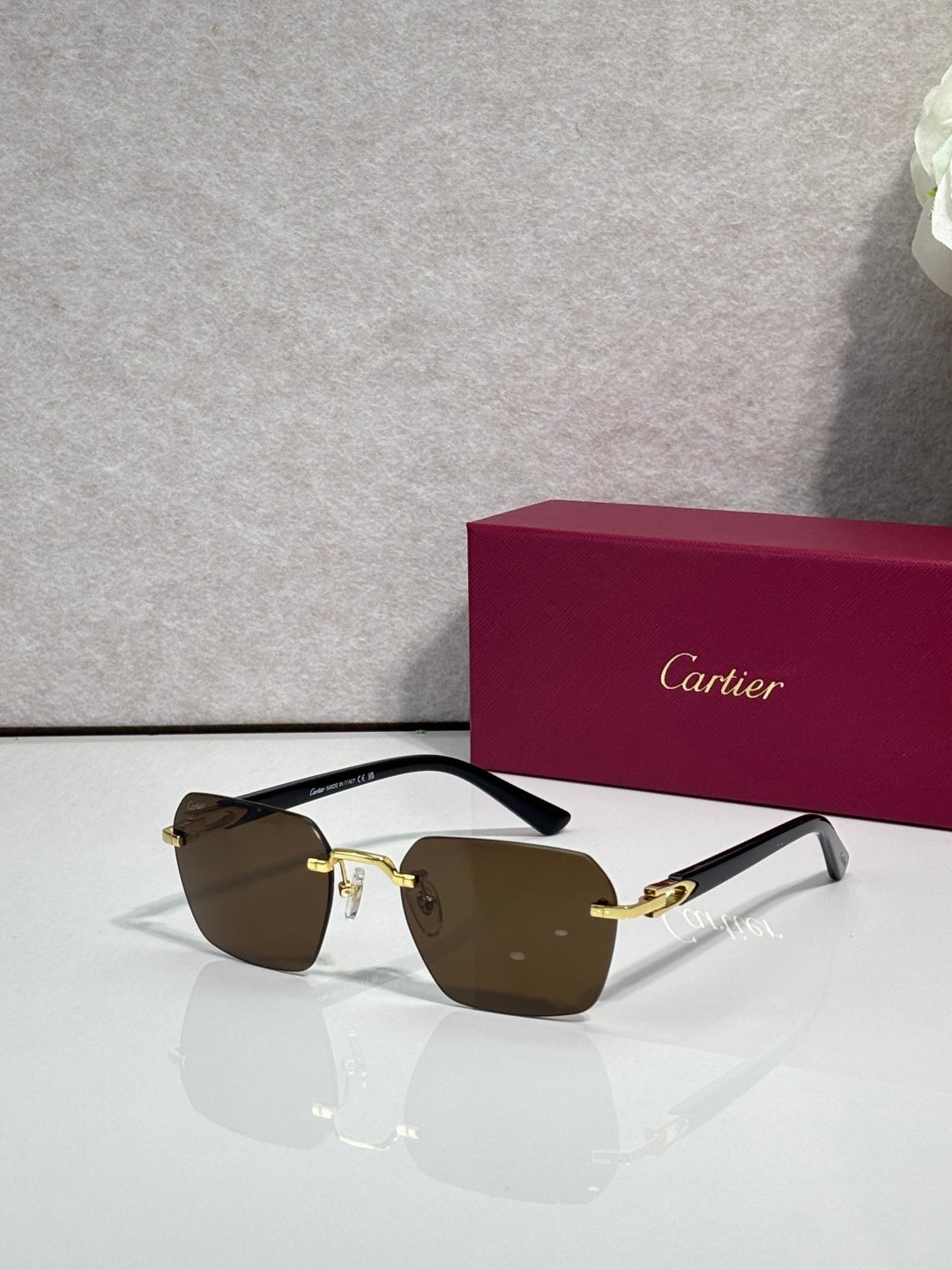 Cartier sunglasses with brown lenses and black frame with gold-tone accents