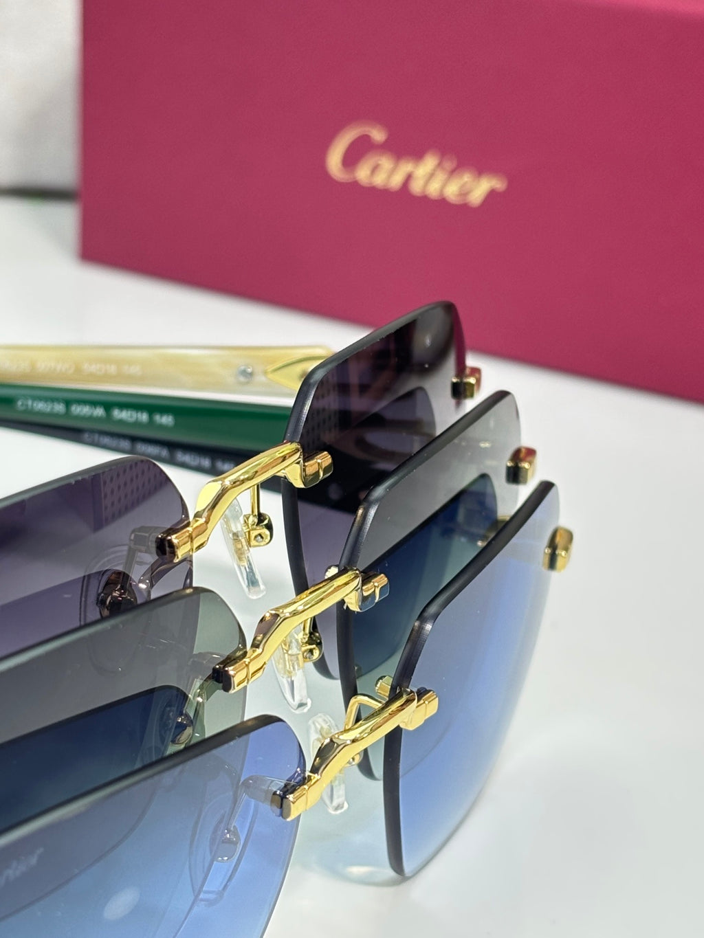Sunglasses close-up with gold hinges and dark lenses in a blue gradient