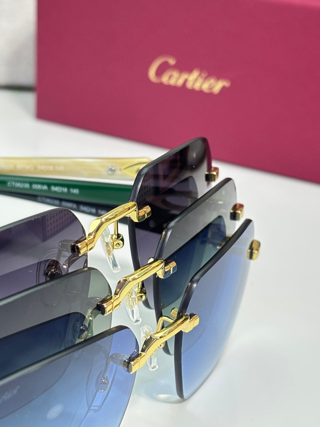 Sunglasses close-up with gold hinges and dark lenses in a blue gradient