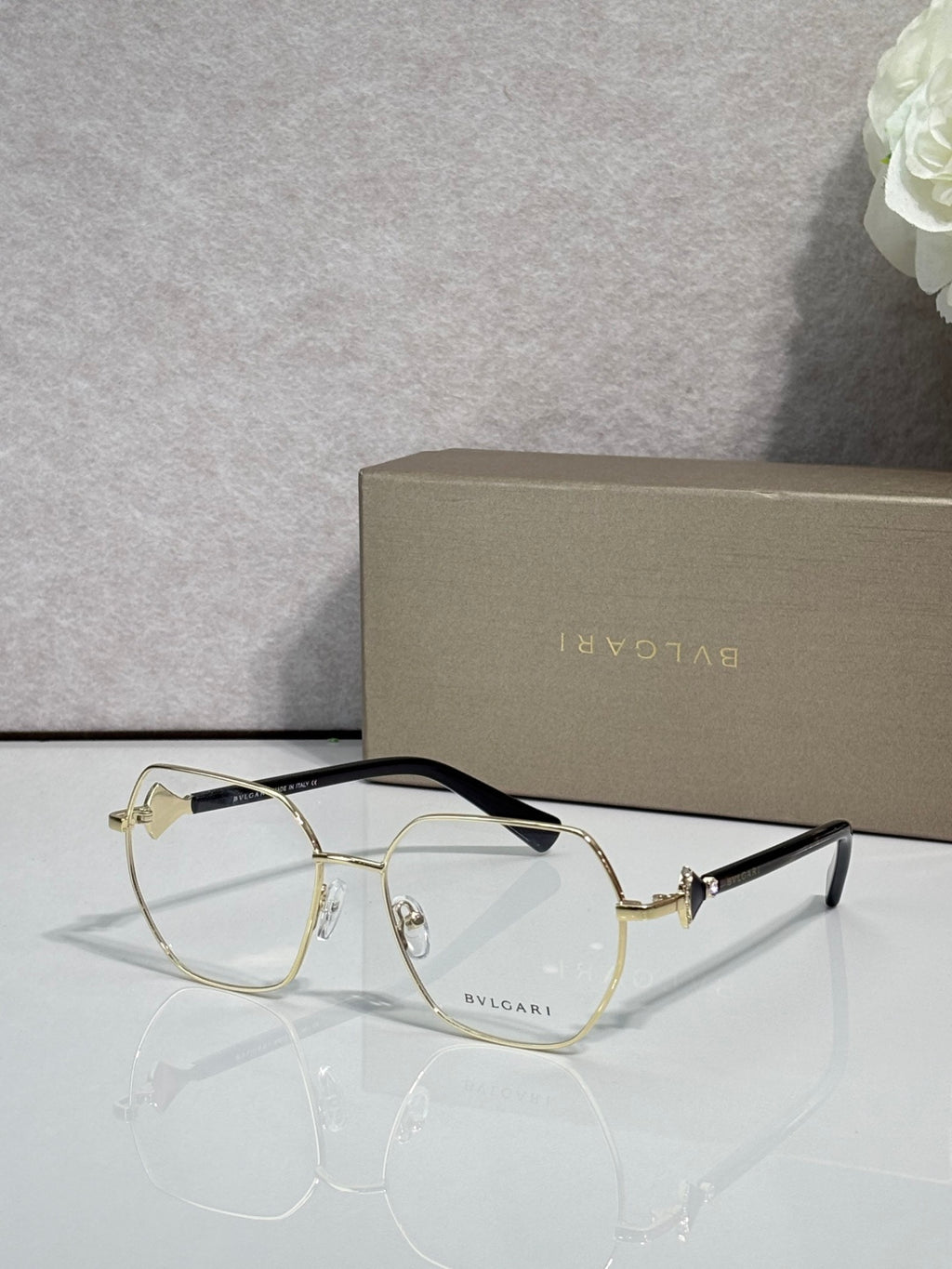 Gold metal round eyeglasses with clear lenses and dark tortoise top rim, logo engraving.