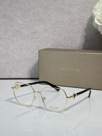 Gold metal round eyeglasses with clear lenses and dark tortoise top rim, logo engraving.