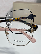 Black and tortoise metal eyeglasses with clear lenses, engraved logo on arms.