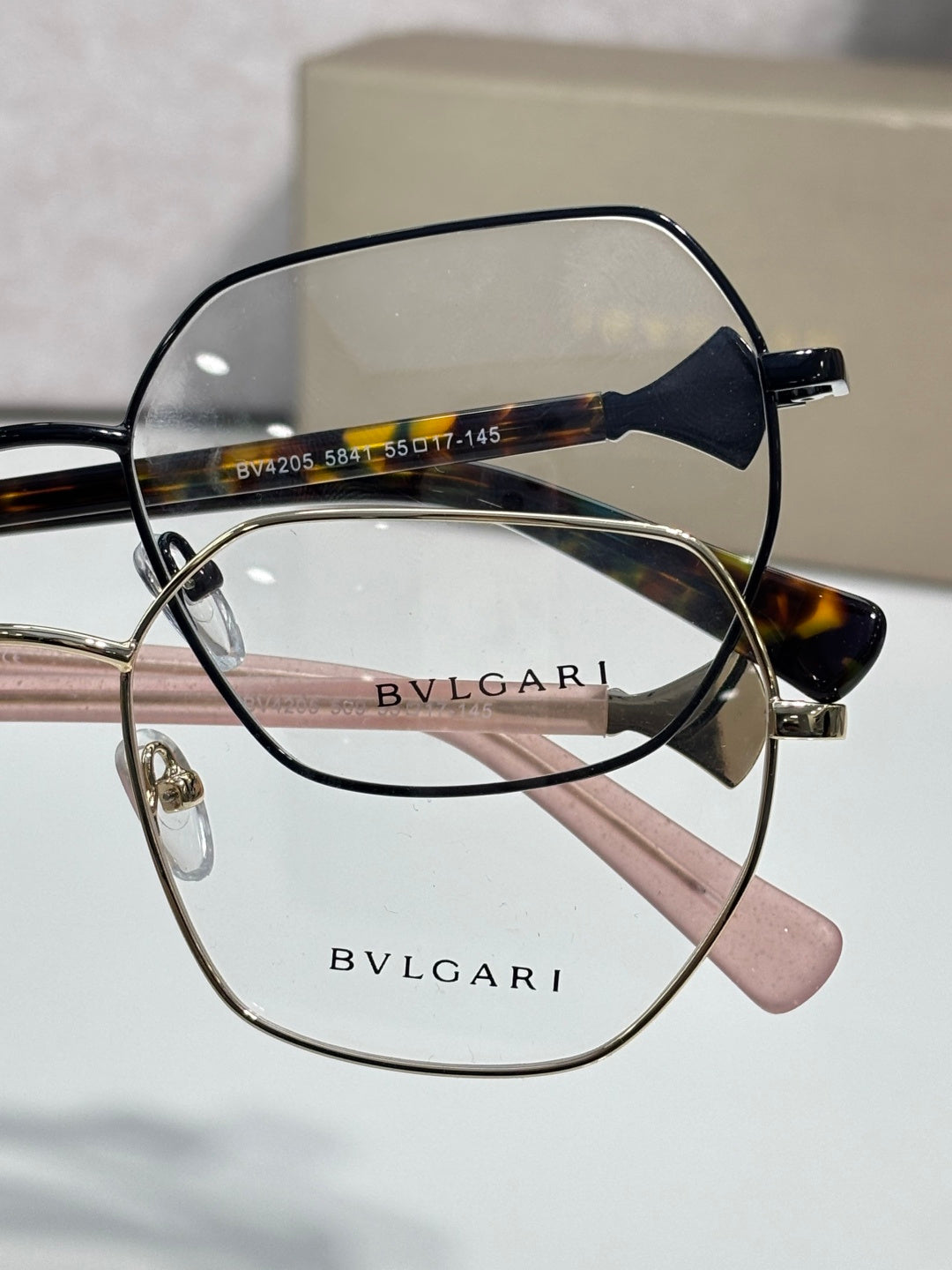 Black and tortoise metal eyeglasses with clear lenses, engraved logo on arms.