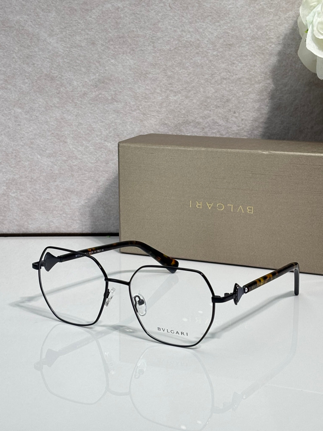 Black metal round eyeglasses with clear lenses and dark tortoise temple arms.