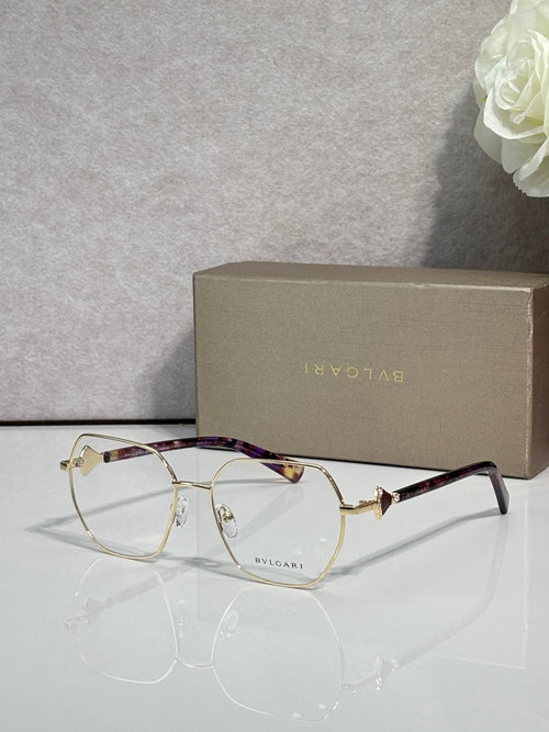 Gold metal round eyeglasses with clear lenses and dark tortoise temples, logo details.