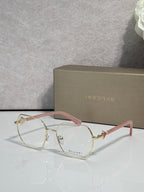 Gold metal round eyeglasses with clear lenses and pink-tinted temple accents, logo.