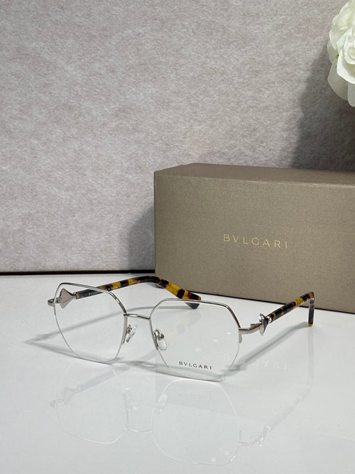 Eyeglasses with clear lenses and gold-tone metal frame, tortoiseshell top bar.