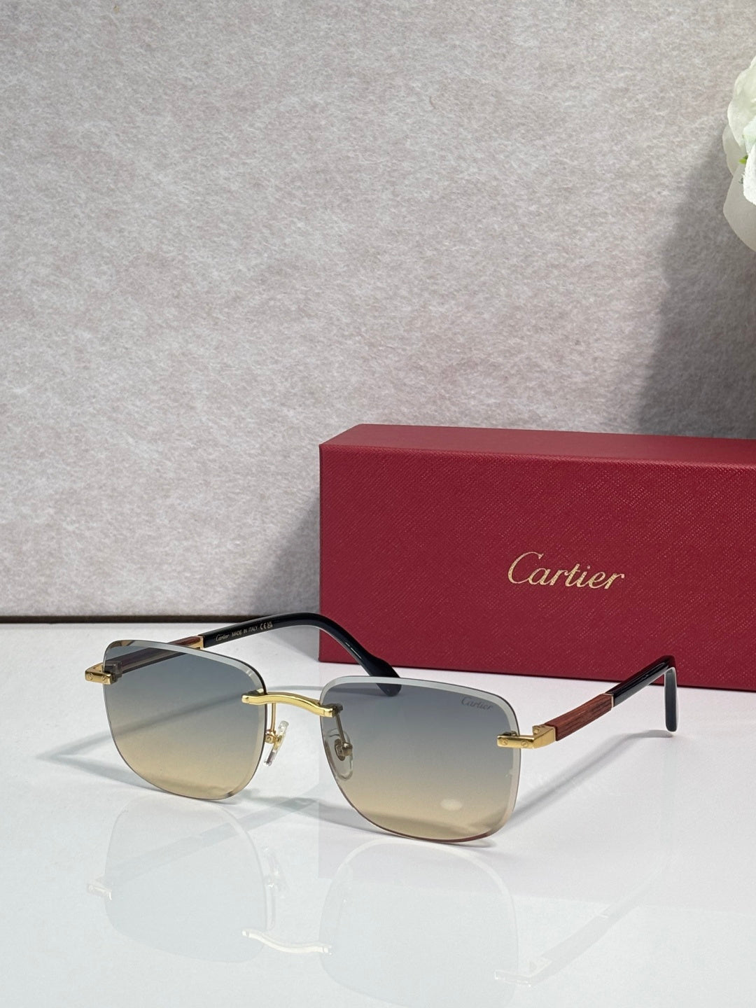 Cartier square sunglasses with clear gray lenses, black frame, and gold-tone bridge