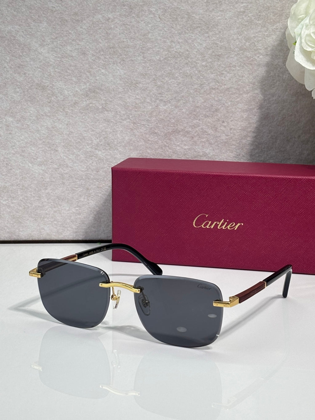 Cartier square sunglasses with dark gray lenses, black frame, and gold-tone hinge details