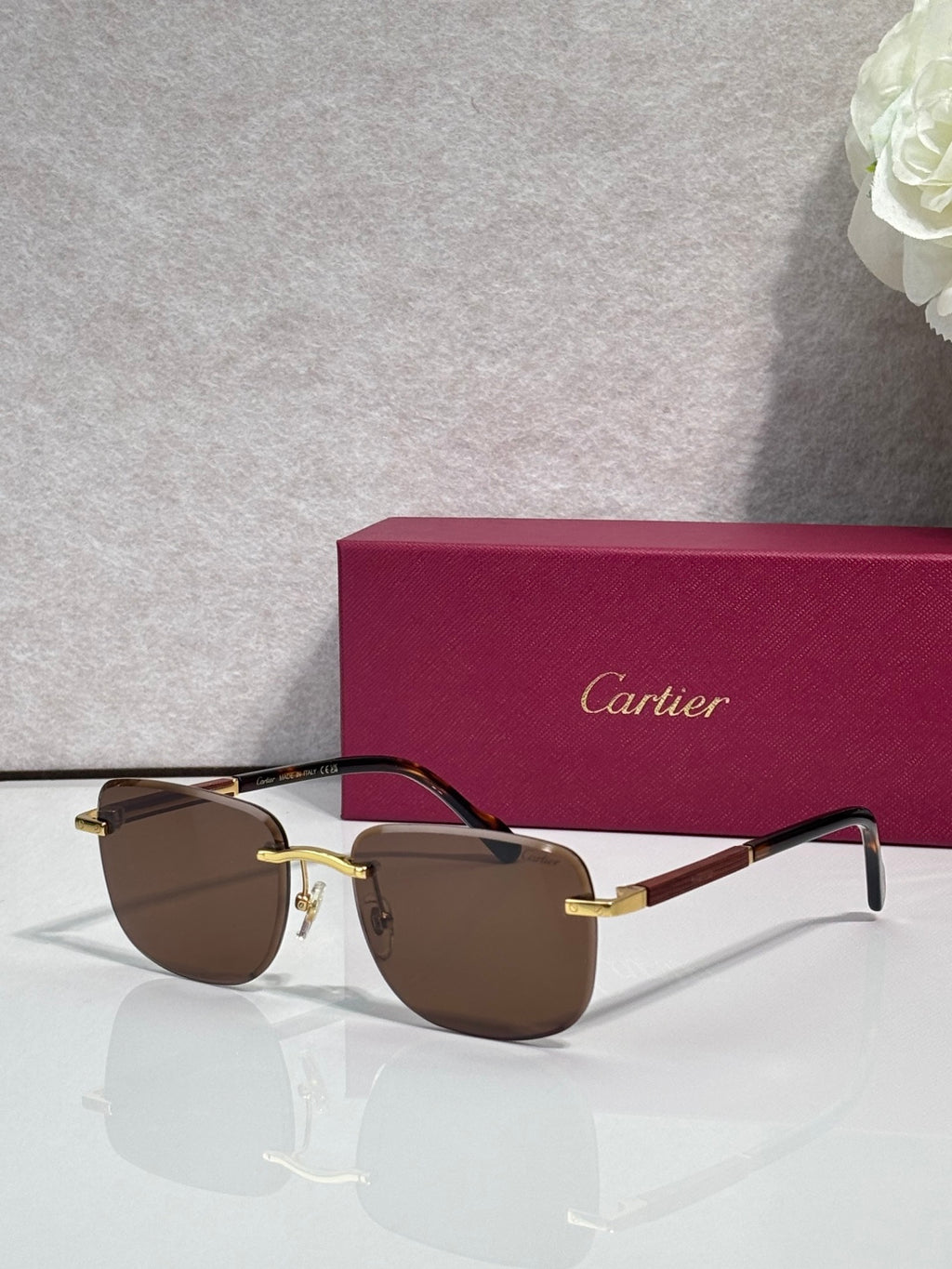 Cartier square sunglasses with dark brown lenses, black frame, and gold-tone accents