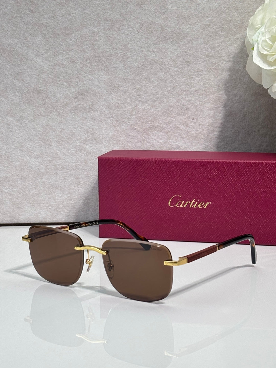 Cartier square sunglasses with dark brown lenses, black frame, and gold-tone accents
