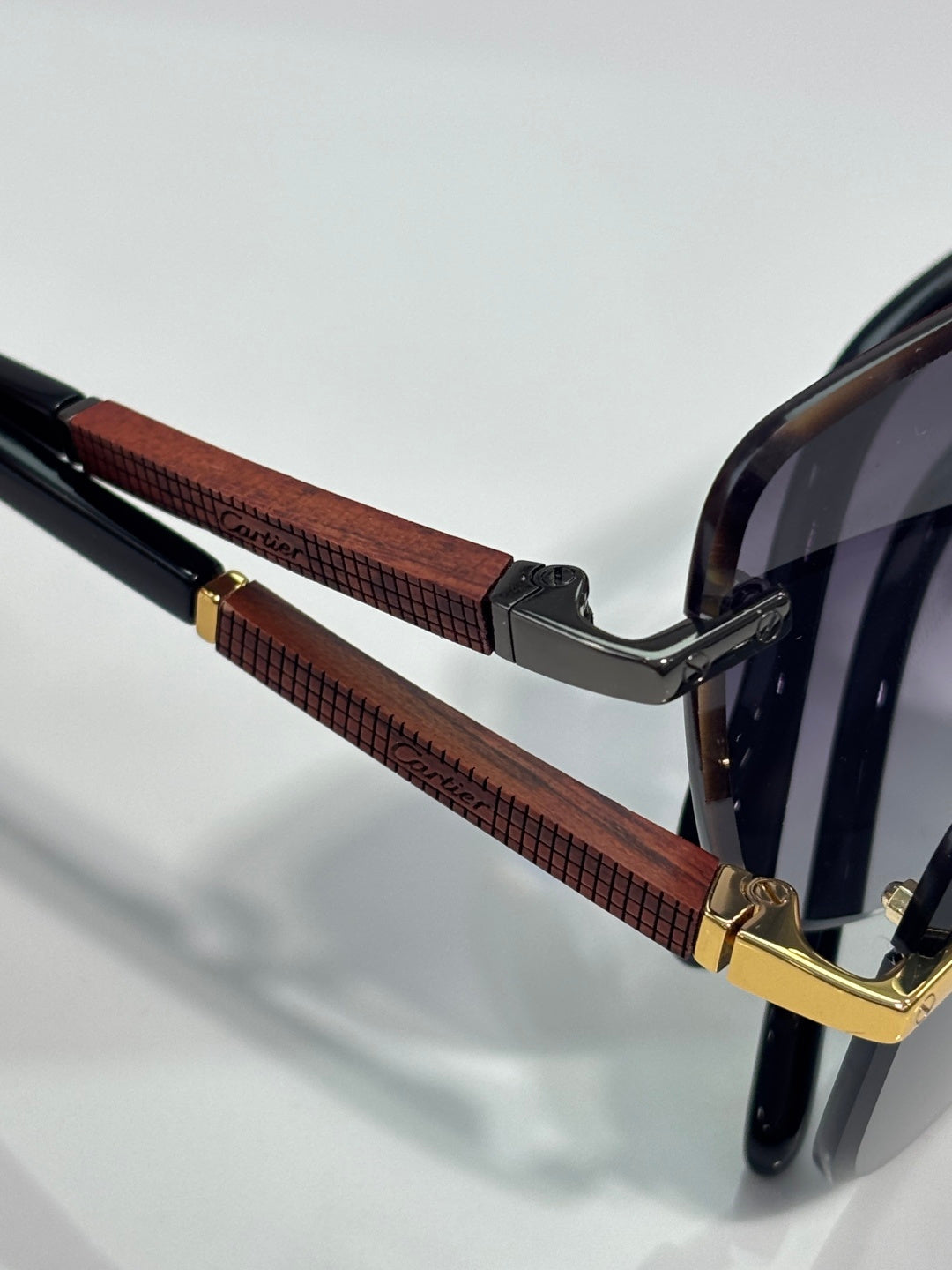 Cartier sunglasses close-up of brown textured temple with gold hinge and dark frame