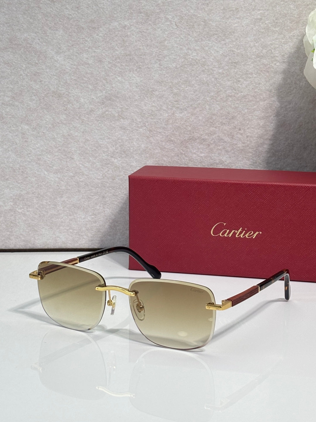 Cartier square sunglasses with light amber lenses, black frame, and gold-tone temples