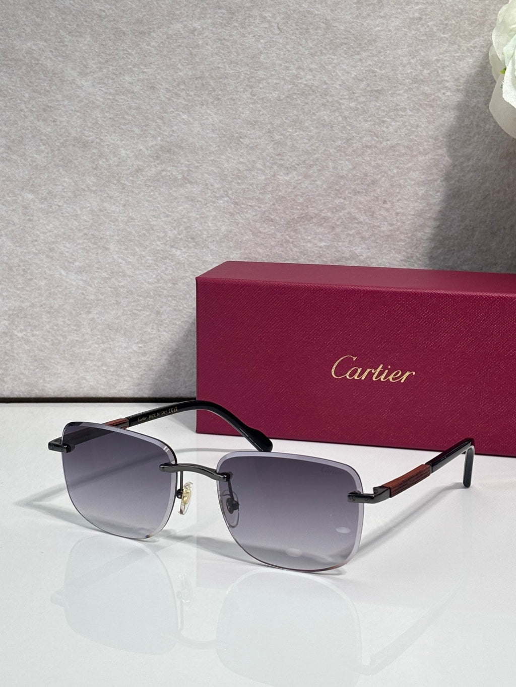 Cartier square sunglasses with dark gray lenses, black frame, and gold-tone accents