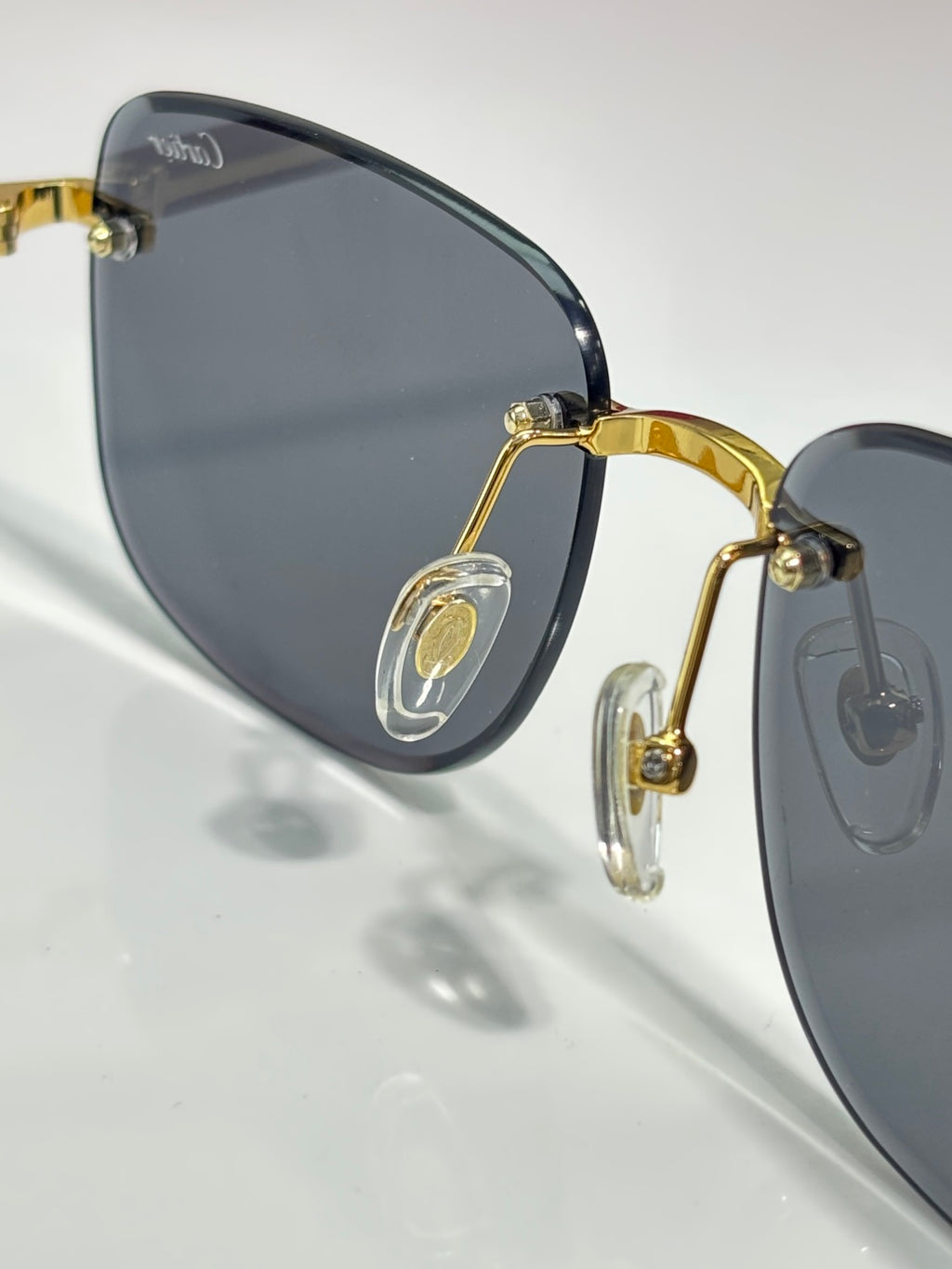 Cartier sunglasses close-up with oval dark lenses and gold-tone bridge hardware