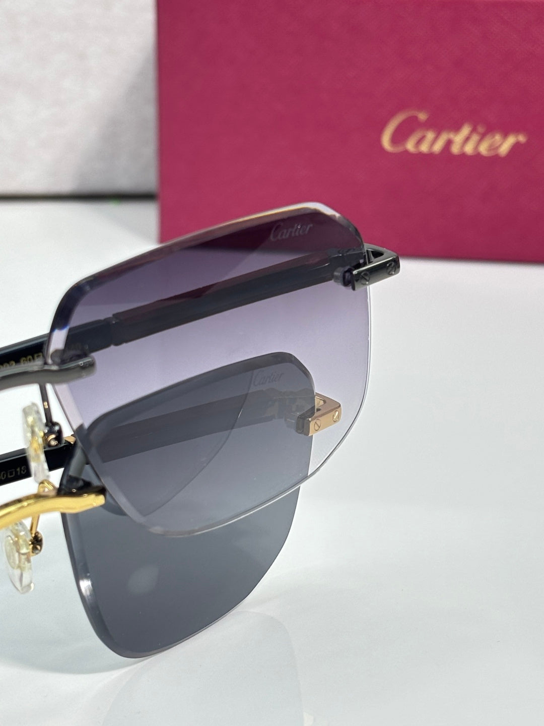 Cartier eyeglasses side view with dark frame and purple-tinted gradient lenses, gold hinge