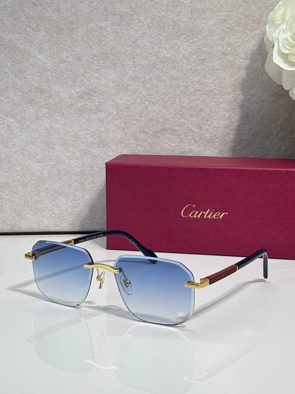 Cartier eyeglasses with dark frames and blue-tinted lenses, gold-tone hinge details